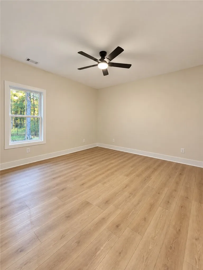 Warm wood flooring and neutral walls define this versatile bedroom space.