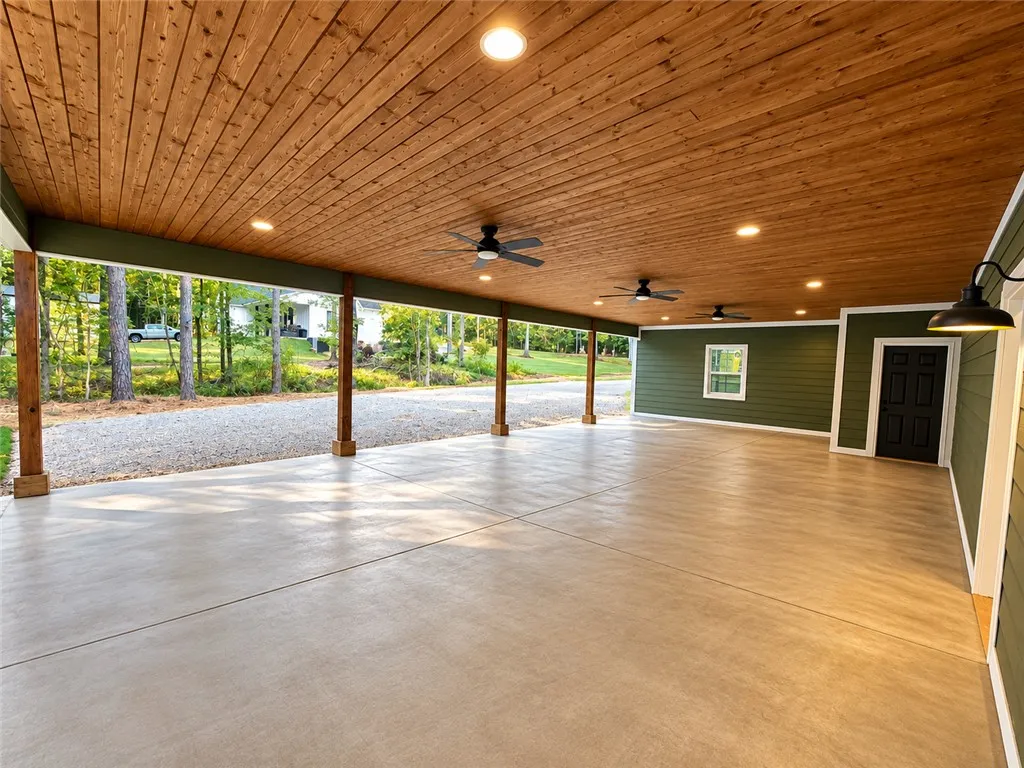 Rich wood plank ceilings and smooth concrete flooring define this massive covered outdoor area.