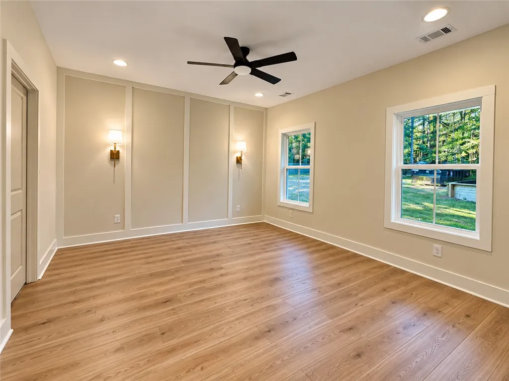 Elegant wall paneling and warm wood flooring define this versatile, light-filled space.