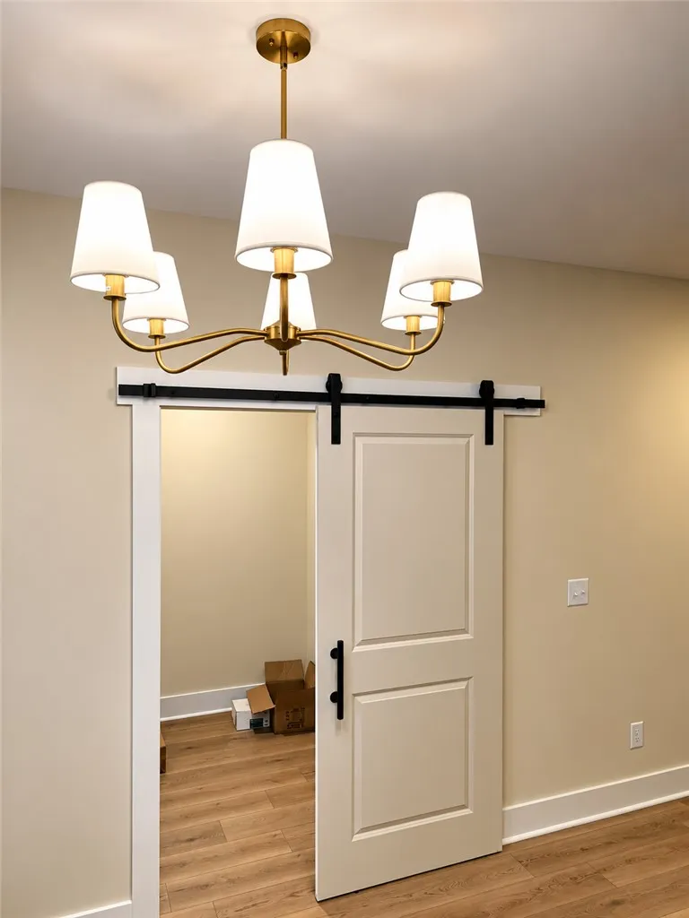 Elegant hardwood flooring anchors this transition space featuring a stylish sliding barn door.