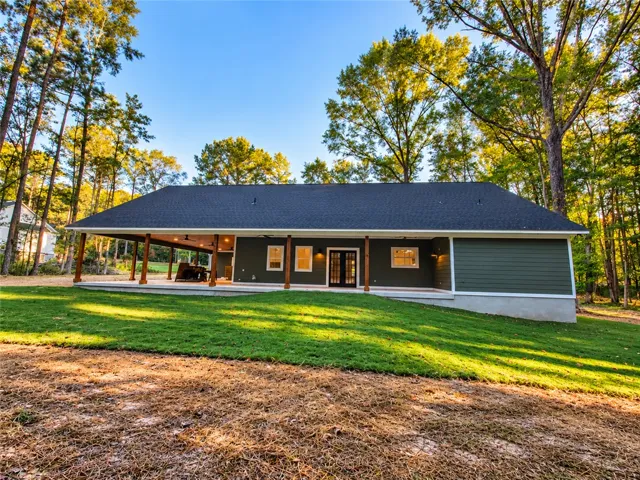 A spacious covered porch runs along the back of this modern ranch-style home.