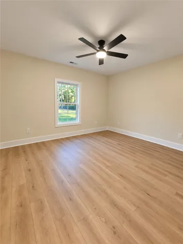 Gleaming wood floors pair with a classic single window looking out to the yard.