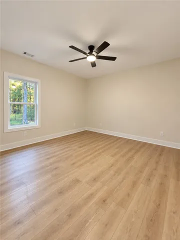 Warm wood flooring and neutral walls define this versatile bedroom space.