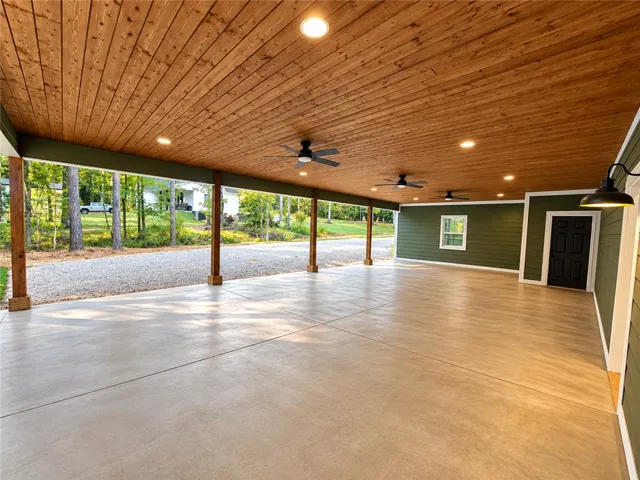 Rich wood plank ceilings and smooth concrete flooring define this massive covered outdoor area.