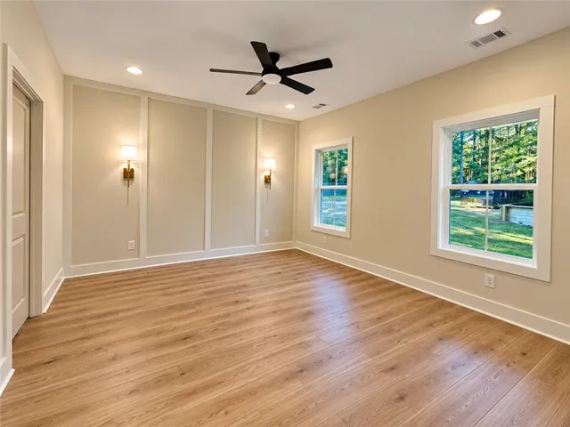 Elegant wall paneling and warm wood flooring define this versatile, light-filled space.