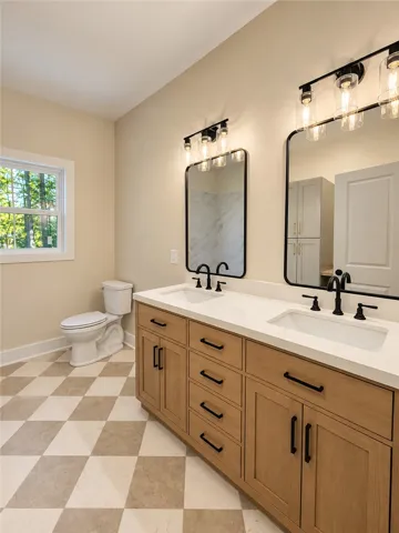 Clean lines and a spacious dual vanity define this elegant primary bathroom.