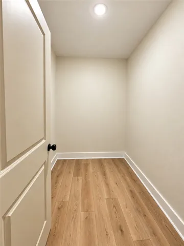Rich wood-look flooring and crisp trim highlight this versatile, recessed-lit closet space.