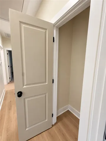 Gleaming wood flooring flows seamlessly into a versatile storage closet with crisp white trim.