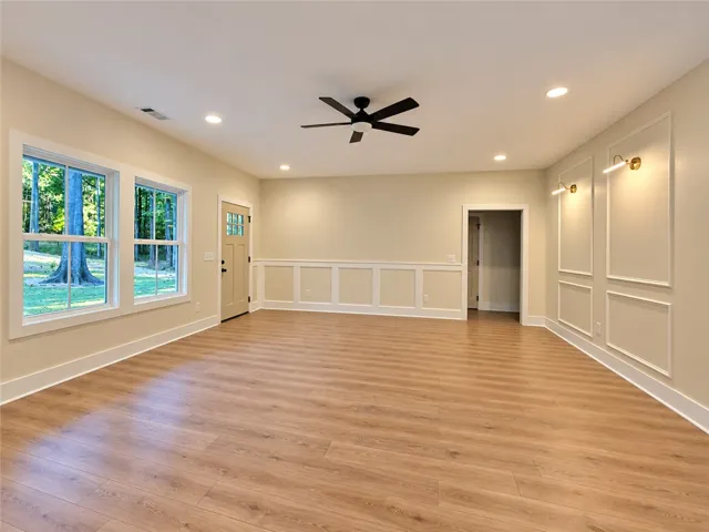 Elegant wainscoting and wall molding complement the rich wood floors and classic windows.
