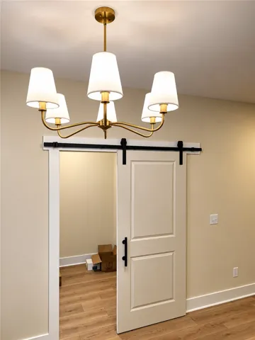 Elegant hardwood flooring anchors this transition space featuring a stylish sliding barn door.