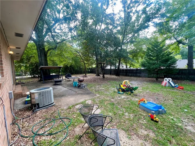Mature trees shade a spacious backyard complete with a concrete patio area.