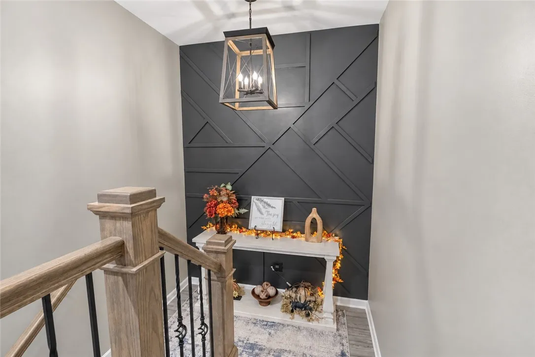 A geometric millwork wall anchors the inviting landing at the top of the stairs to the second floor.
