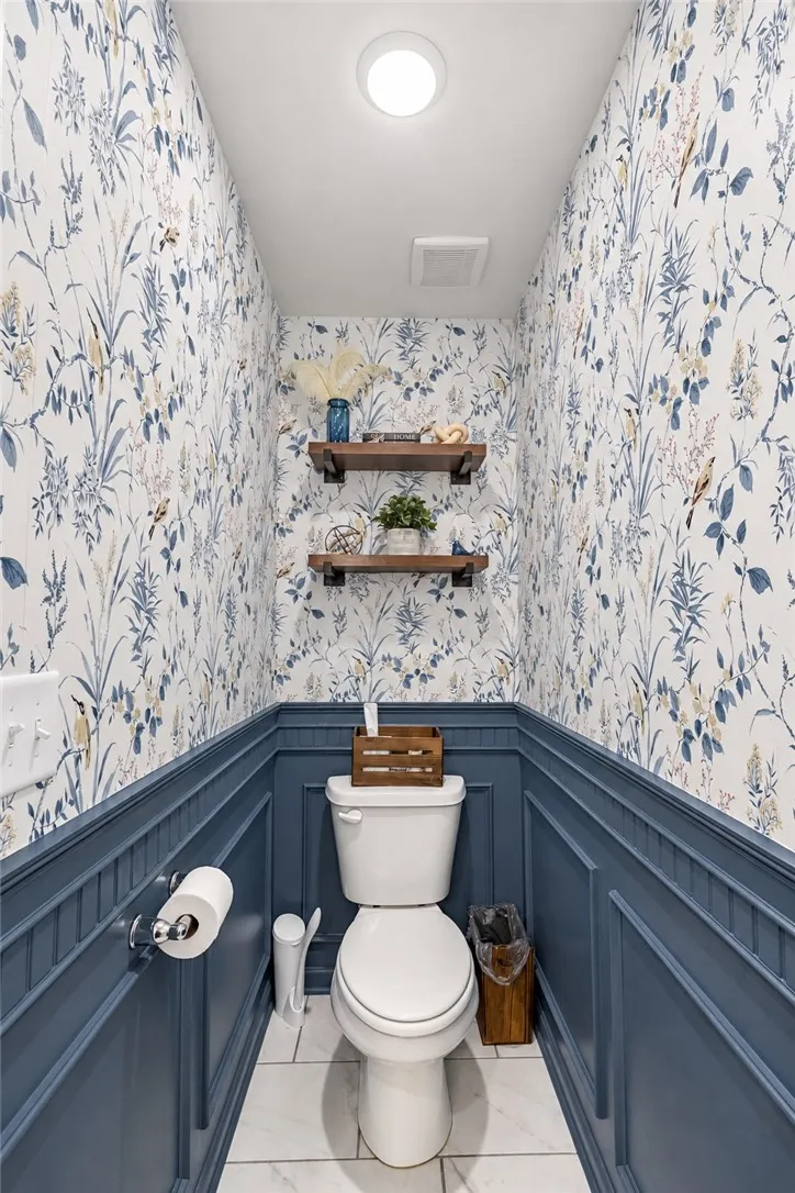 Classic wainscoting and elegant wallcoverings enhance this charming powder room.