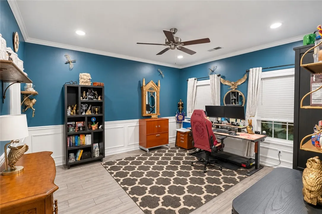 Rich wainscoting and smooth wood-look flooring establish an elegant architectural foundation in this versatile workspace.