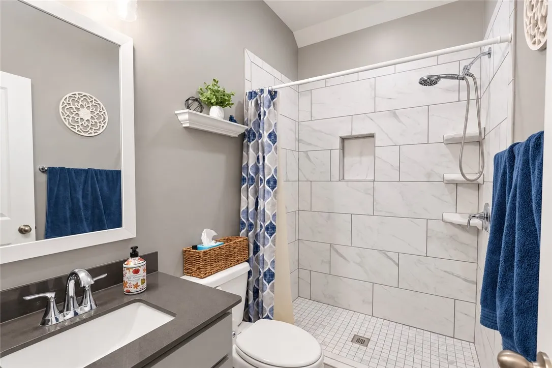 High ceilings and clean tiled finishes define this well-appointed bathroom.