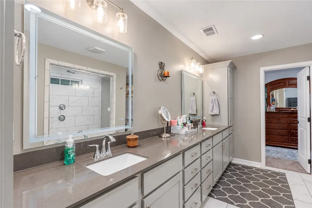 An expansive double vanity with stone countertops highlights this refined master bathroom.