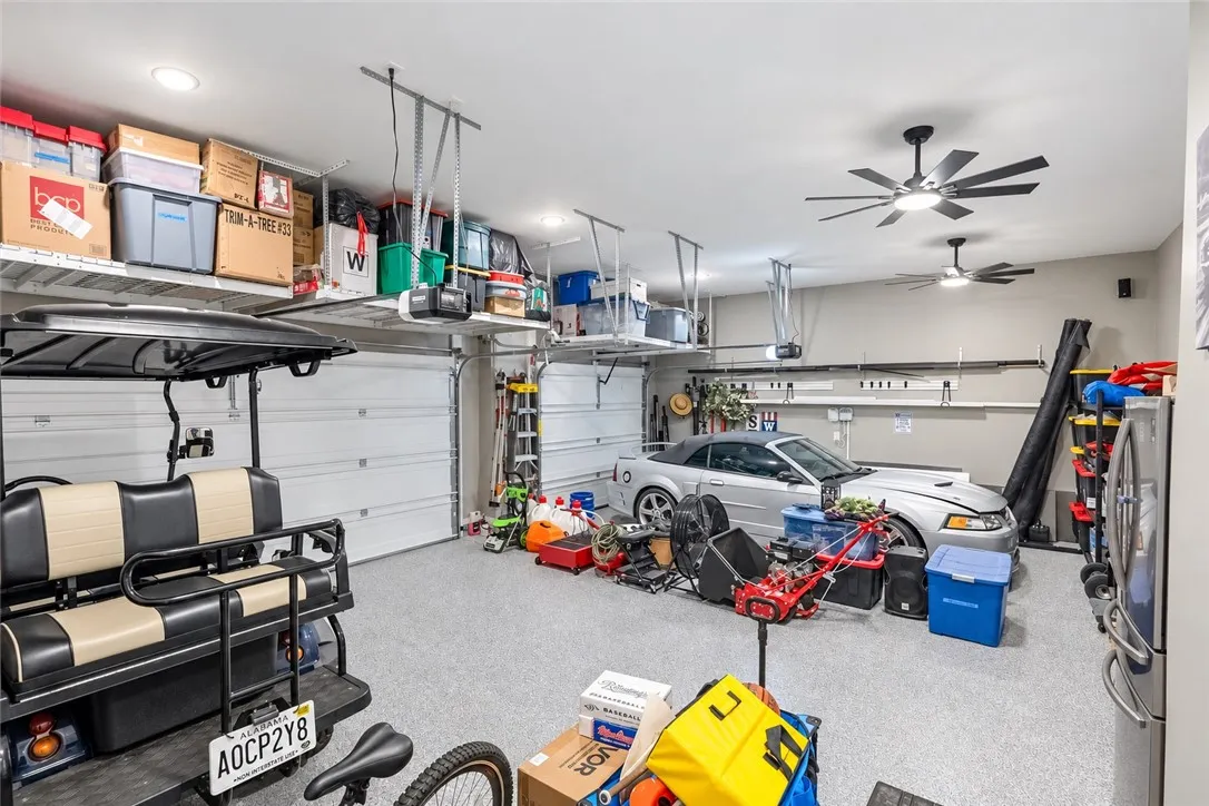 An organized multi-vehicle garage with durable speckled flooring and overhead storage racks.