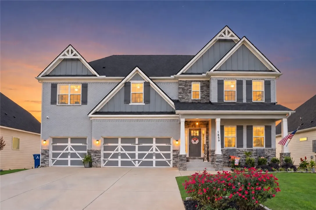A craftsman exterior blends brick and stone accents beneath an array of gables.