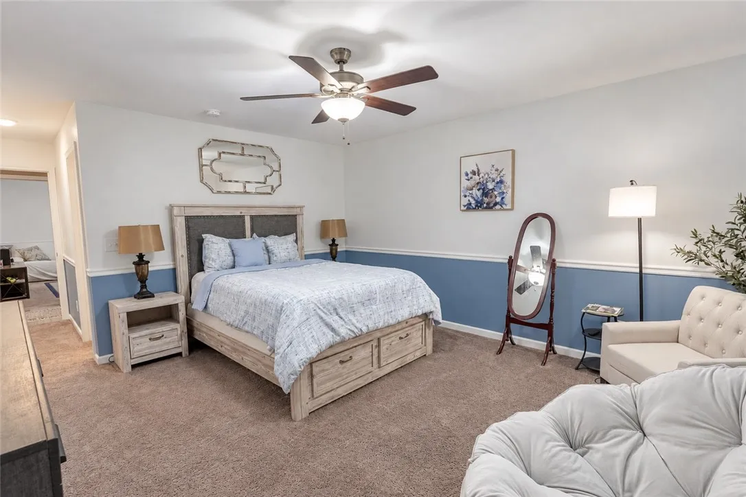Plush carpeting and two-toned walls with classic chair rail molding anchor this restful retreat.