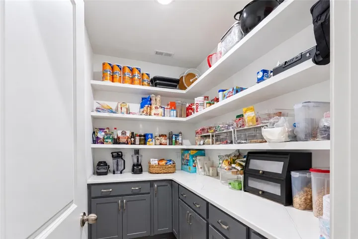 Ample built-in shelving and solid counters maximize storage efficiency in this walk-in pantry.