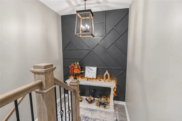 A geometric millwork wall anchors the inviting landing at the top of the stairs to the second floor.