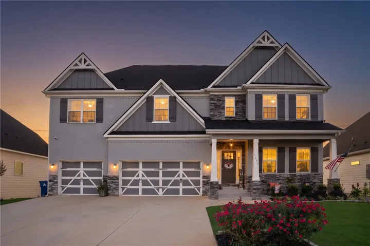 Striking architectural design defines this multi-gabled residence with stone accents and a welcoming front porch.