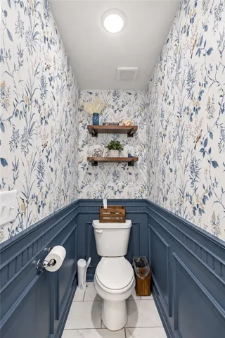 Classic wainscoting and elegant wallcoverings enhance this charming powder room.