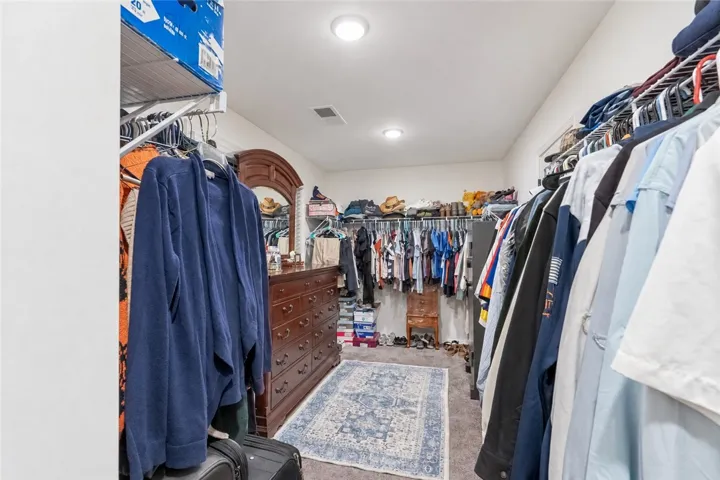 Ample storage options define this functional walk-in closet space with recessed overhead lighting.