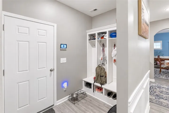 An organized transition space features built-in storage lockers and durable wood-look flooring.