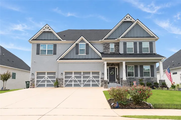 Gable rooflines and stone accents define this modern two-story home with a spacious driveway.