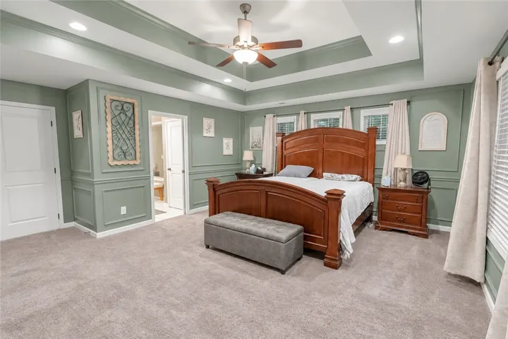 An elegant tray ceiling and detailed wall molding elevate this comfortable private retreat.