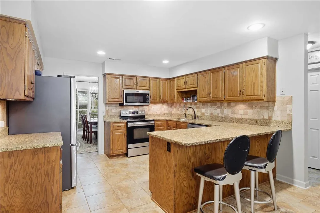 Rich wood cabinetry paired with granite countertops defines this functional kitchen space.