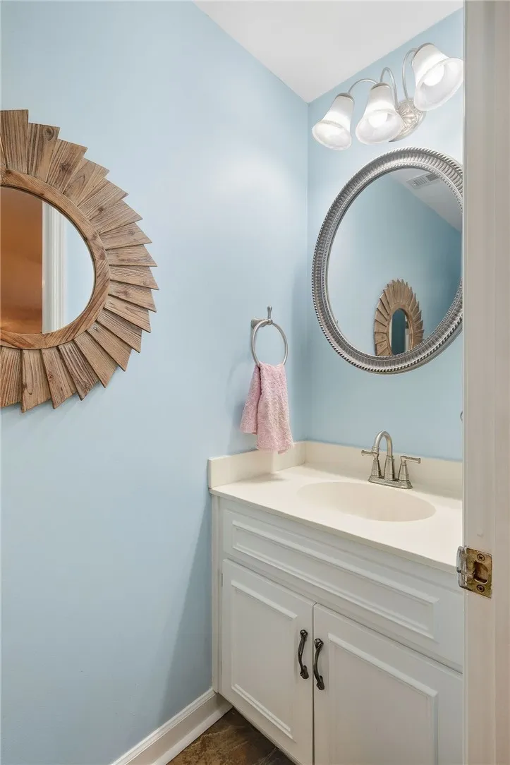 An elegant vanity with a solid countertop highlights this classic powder room.