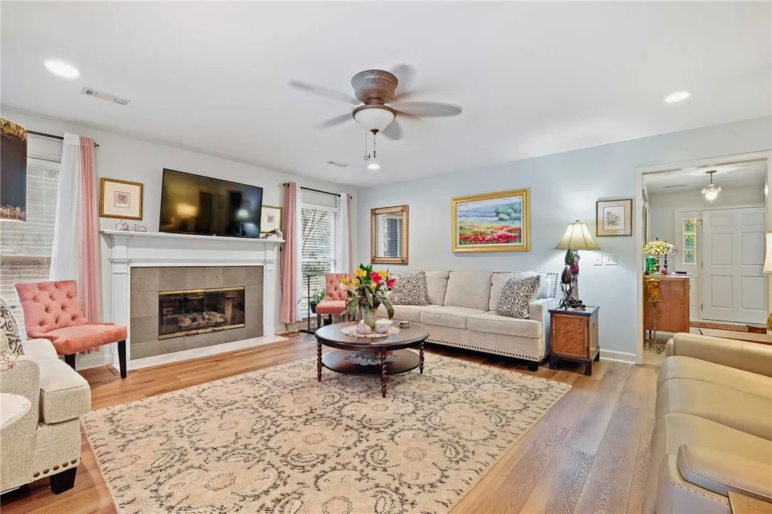Warm hardwood flooring and a classic fireplace create a welcoming focal point in this living area.