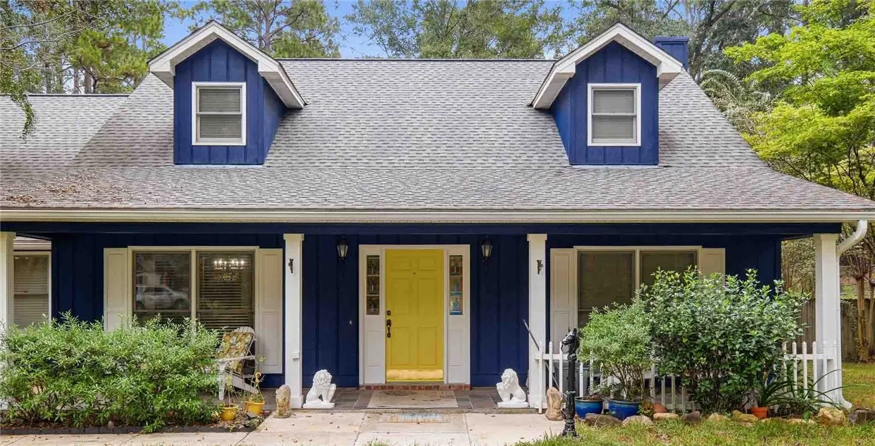 Board and batten siding meets dormer windows along a welcoming covered front porch.