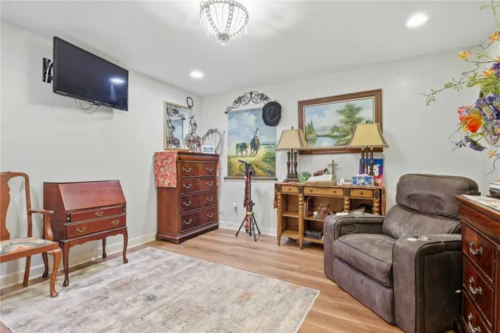 Gleaming wood floors pair with recessed downlighting to create a welcoming and comfortable atmosphere in this study with also could serve as a bedroom