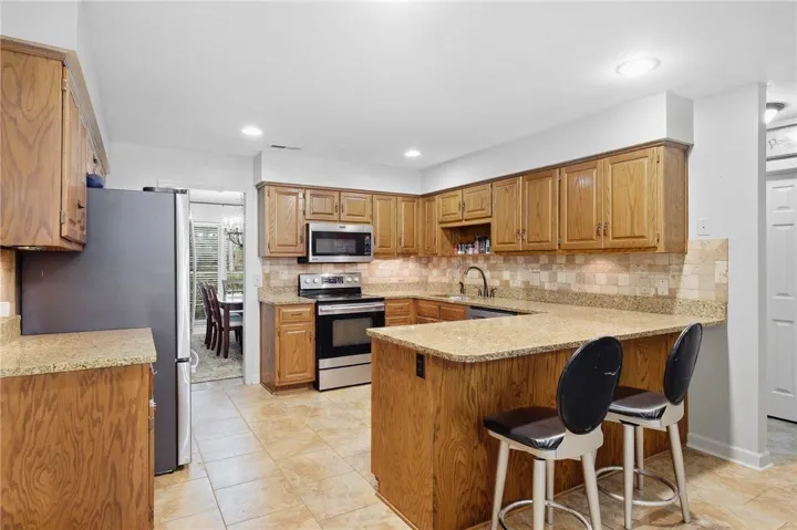 Rich wood cabinetry paired with granite countertops defines this functional kitchen space.