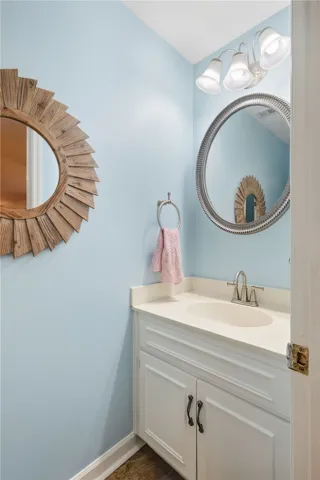 An elegant vanity with a solid countertop highlights this classic powder room.