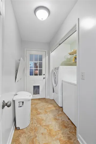 A functional laundry area with tiled flooring leads directly to the backyard.