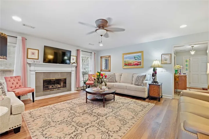 Warm hardwood flooring and a classic fireplace create a welcoming focal point in this living area.