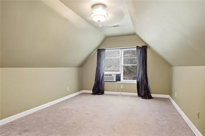 Angled ceilings and soft carpeting create a cozy, private atmosphere in this upper-level space.