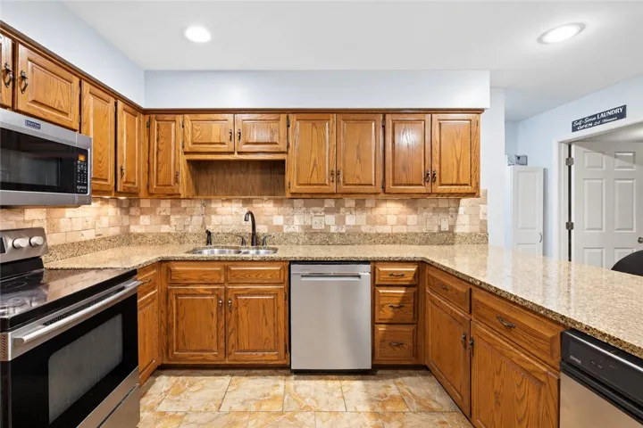 Rich wood cabinetry complements polished stone countertops and modern stainless steel appliances.