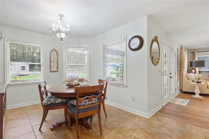 Tiled flooring and multiple windows organize this comfortable dining area next to french doors.
