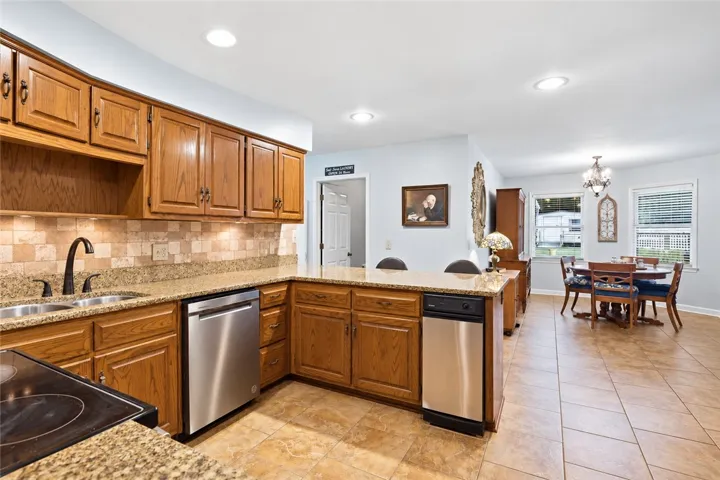 Oak cabinetry and granite countertops define this functional kitchen, which transitions smoothly into a dining area.