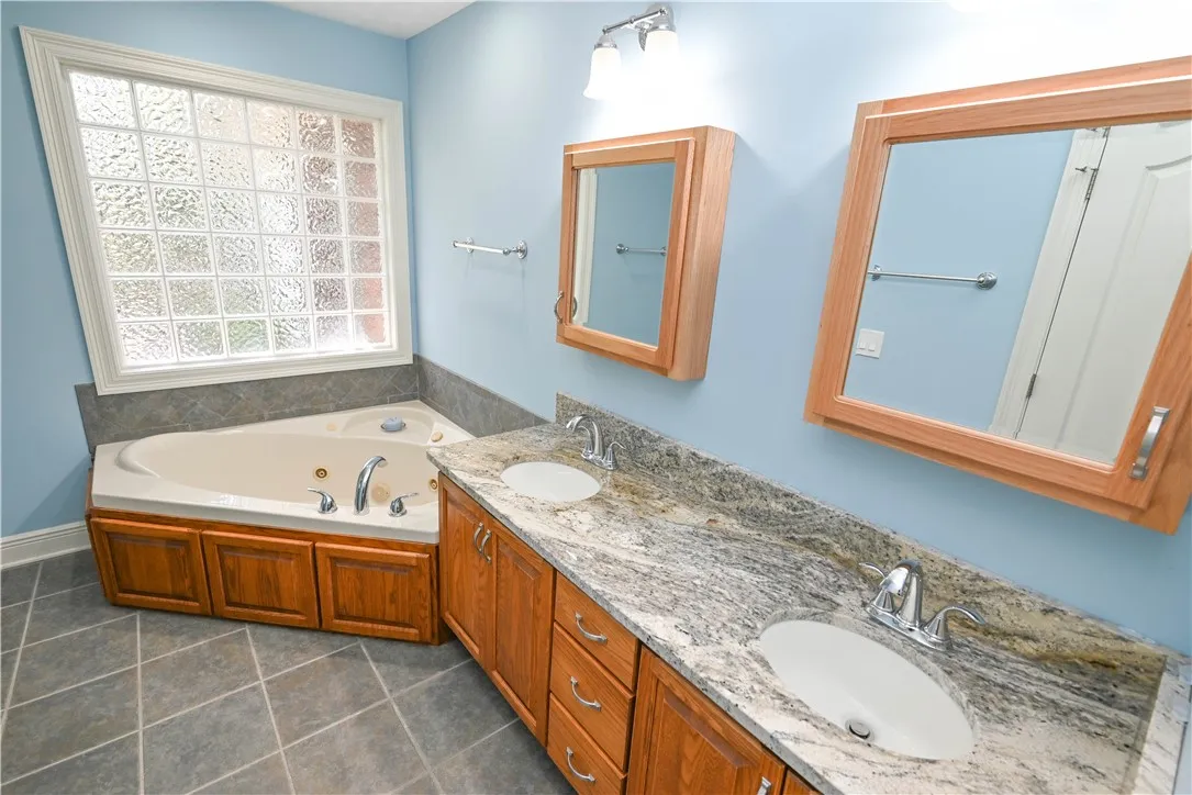 Primary bath vanity with double sinks undermounted in granite.