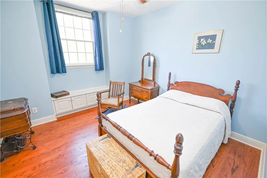 Bedroom 2 with built-in bench storage, walk-in closet, and hardwood floors.