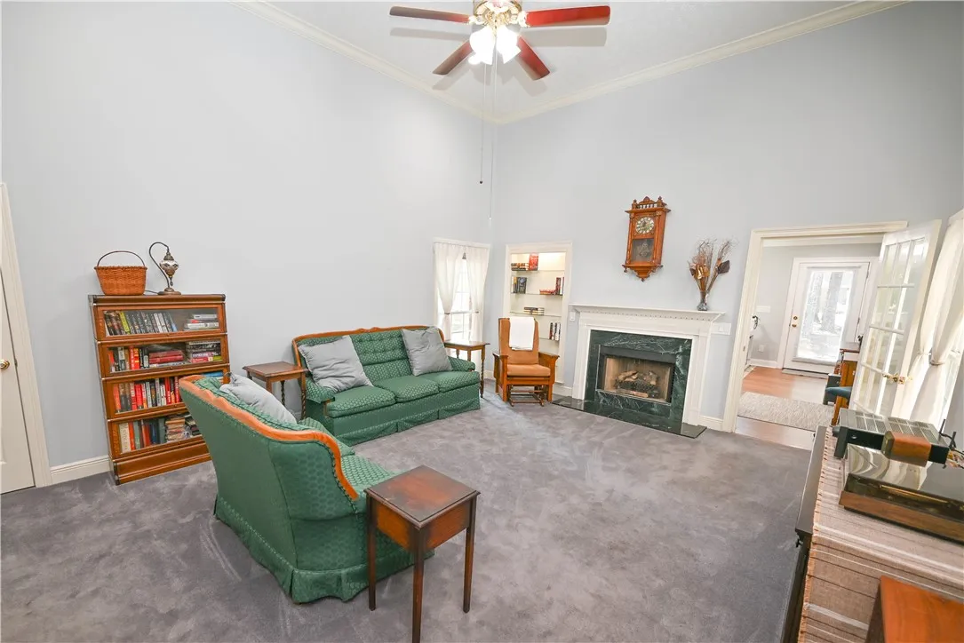 Great room features a cozy gas-log (can be wood-burning) fireplace with marble surround as its focal point. (Back right: sunroom.)