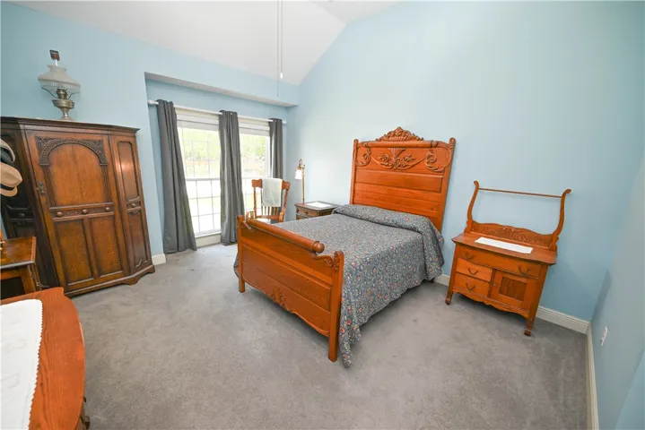Spacious main level primary bedroom with vaulted ceiling and large windows.