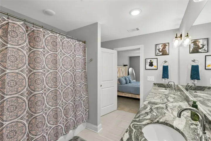 Gleaming stone countertops and modern fixtures elevate this well-appointed washroom.