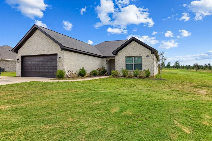 Timeless brick architecture defines this modern residence nestled alongside a manicured green lawn.